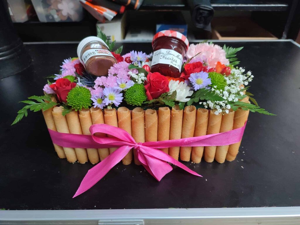 Composition florale originale avec gourmandises, La Roseraie Bapaume